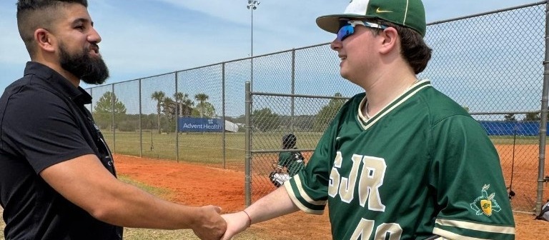 Mauricio greeting a baseball player on the field